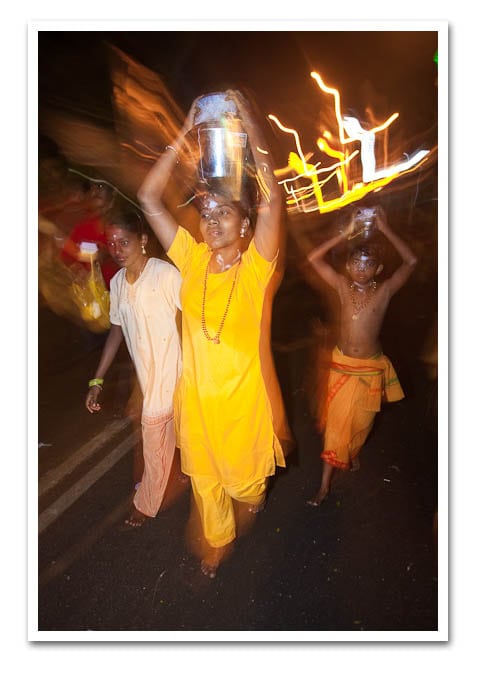 A devotee carring her kavadi of milk. A Devotee carring her kavadis of milk.