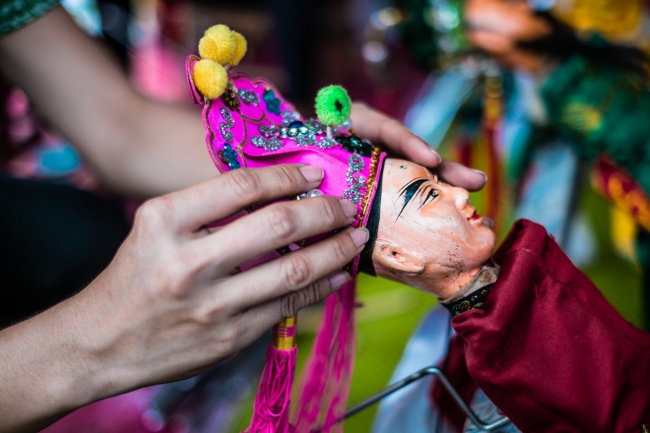 Wei Ling prepares a puppet for it's performance.