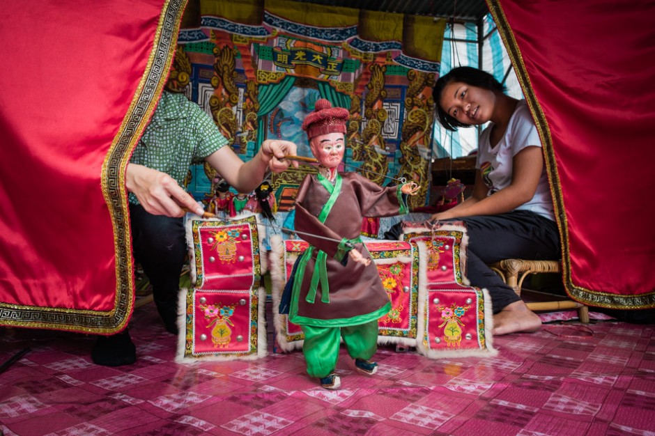 Pei Goh looks on as her sister Wei Ling controls her puppet.